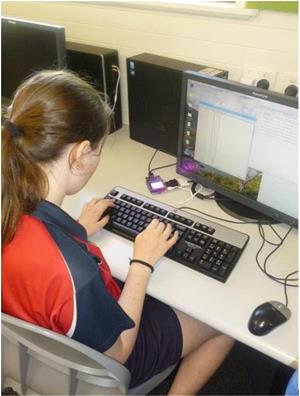 Brown-haired girl in uniform typing on computer