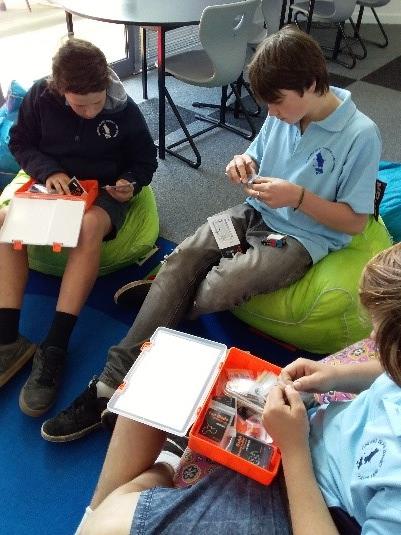 Image of a three primary school males setting up their circuits.