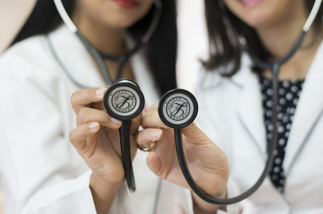 Decorative image of two female doctors holding their stethoscopes to the camera
