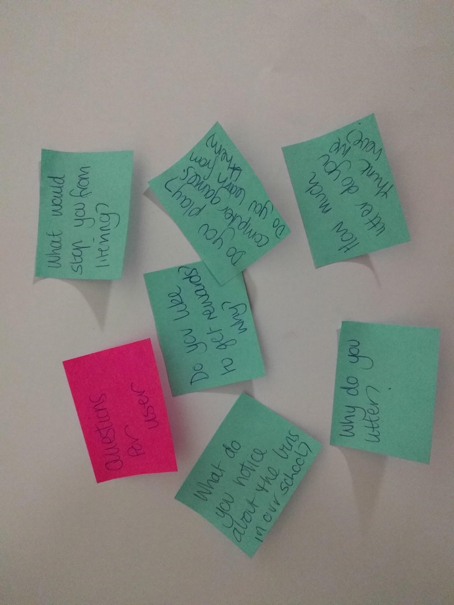 green and pink sticky notes arranged randomly on a board
