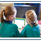 Image of two children in green uniforms taken from behind