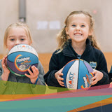 Two girls holding basketballs