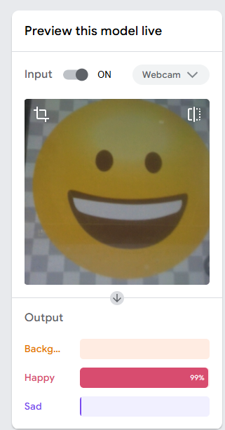 Screenshot of Google Teachable Machine showing a live image classification model. A yellow smiling face emoji is displayed in the webcam preview. Below, the output probabilities show Happy: 99%, while Background and Sad have very low confidence scores.